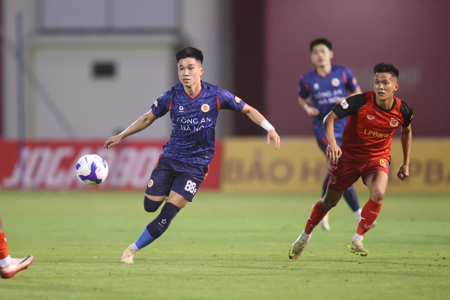 Cầu thủ Công an Hà Nội kiểm soát bóng dưới áp lực từ cầu thủ Ninh Bình.