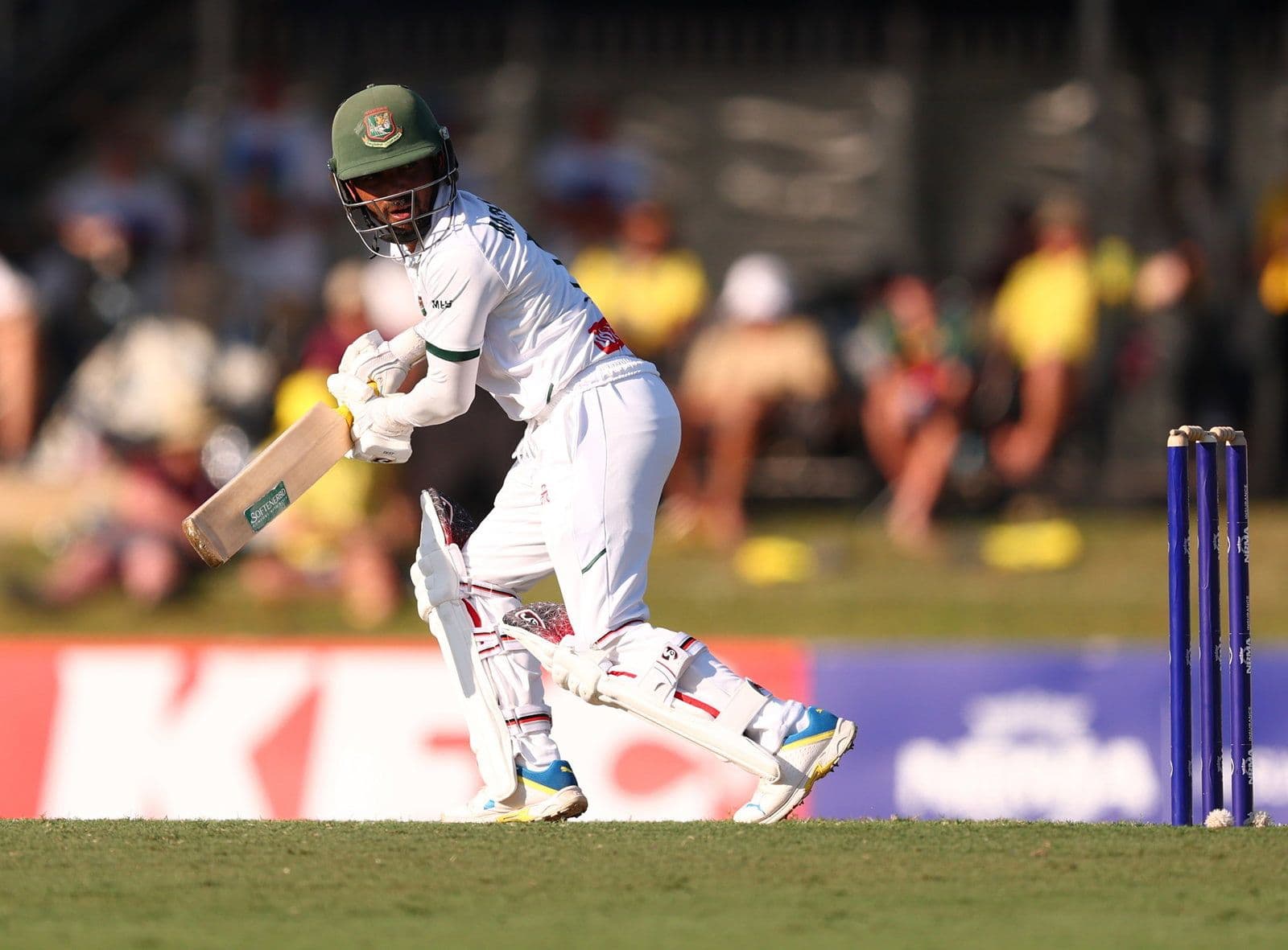 Cầu thủ cricket Bangladesh trong trang phục thi đấu đang đánh bóng trên sân Marrara, Darwin, thể hiện tinh thần chiến thắng bất ngờ trước Úc.