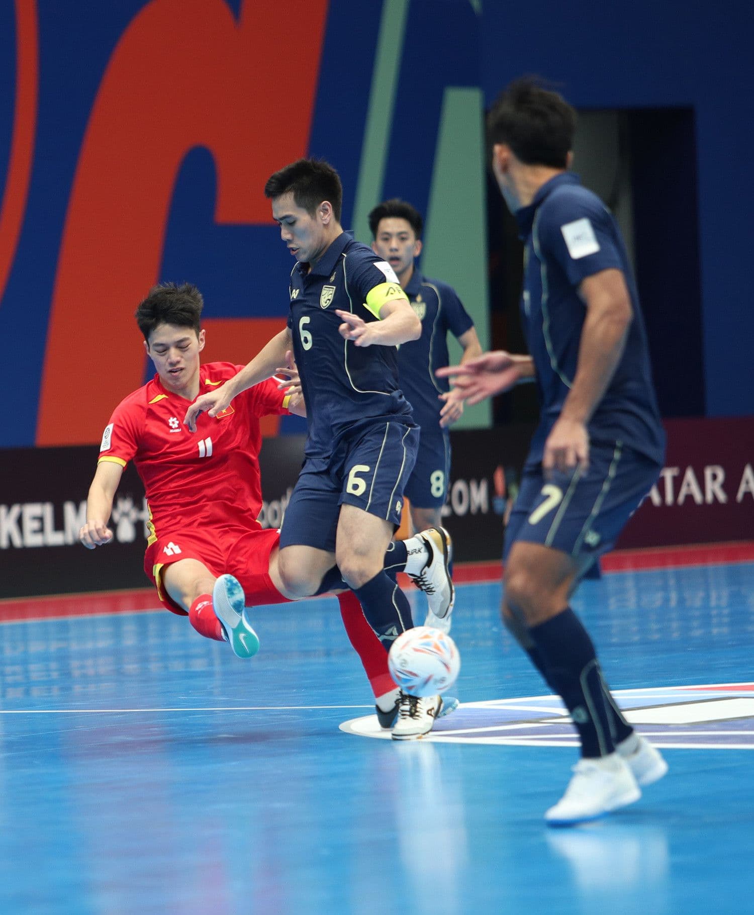 Cầu thủ futsal Việt Nam số 11 nỗ lực tranh bóng với đối thủ Thái Lan trong tình huống khó khăn
