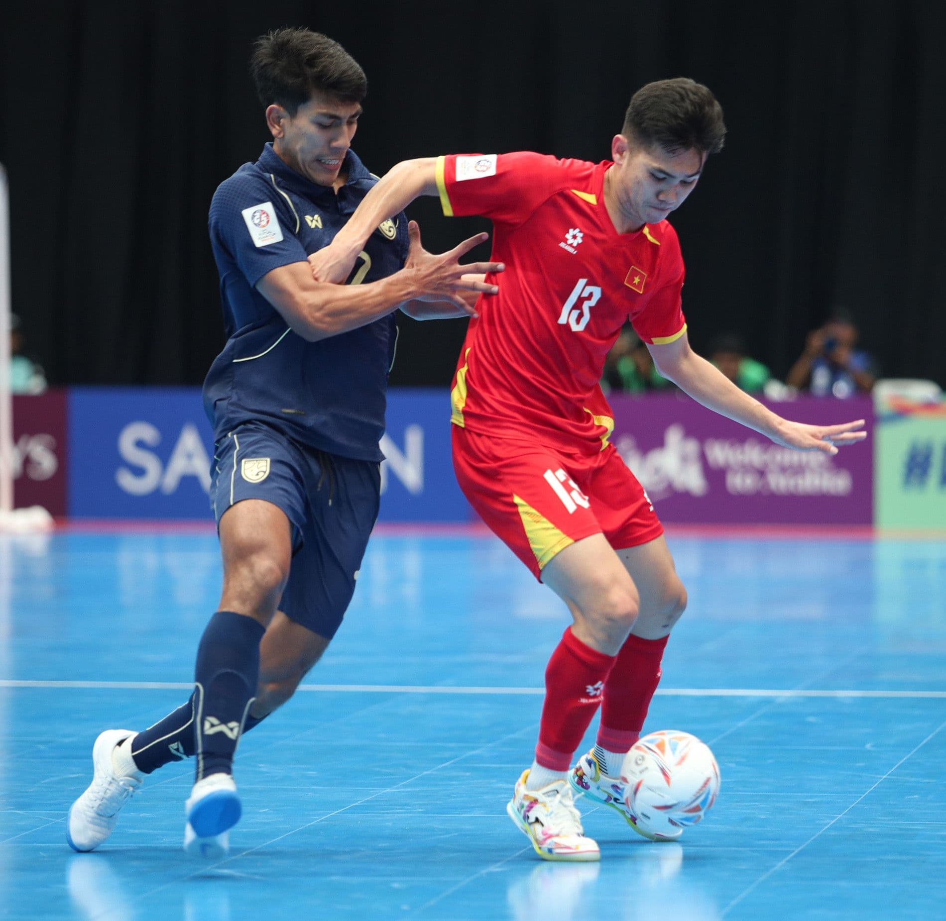 Cầu thủ futsal Việt Nam số 13 giữ bóng trước sự truy cản quyết liệt của cầu thủ Thái Lan