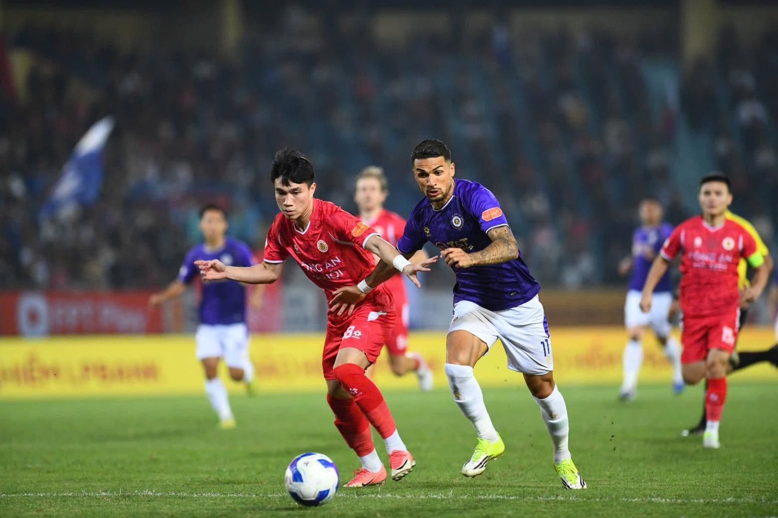 Cầu thủ Hà Nội FC và CAHN tranh giành bóng, thể hiện sự cạnh tranh gay gắt trên đường đua V-League