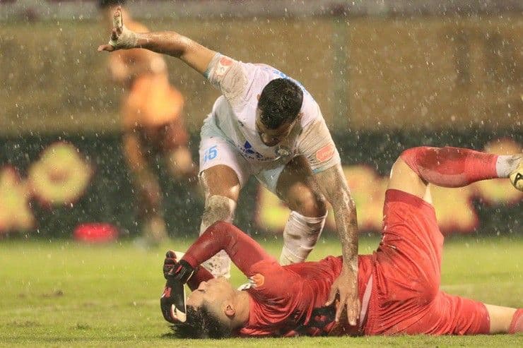 Cầu thủ HAGL và Nam Định tranh chấp quyết liệt trên sân cỏ ẩm ướt, thể hiện sự kịch tính của trận đấu V-League.