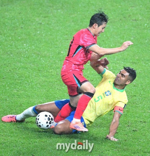 Cầu thủ Hàn Quốc tranh chấp quyết liệt với cầu thủ Brazil, thể hiện tinh thần thép.