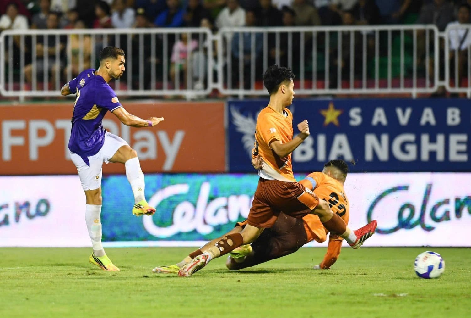 Cầu thủ Hoàng Anh Gia Lai và Hà Nội FC tranh bóng quyết liệt, thể hiện cuộc chiến sinh tồn căng thẳng tại V-League.