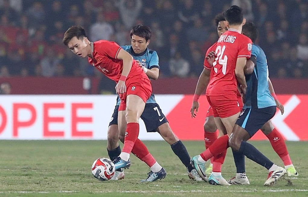 Cầu thủ Hoàng Đức và đồng đội của đội tuyển Việt Nam tranh chấp bóng với đối thủ Singapore.