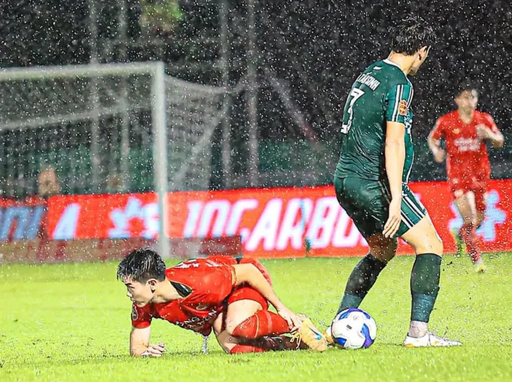 Cầu thủ Huỳnh Tấn Sinh đứng cạnh Đình Bắc đang nằm sân sau pha phạm lỗi thô bạo.