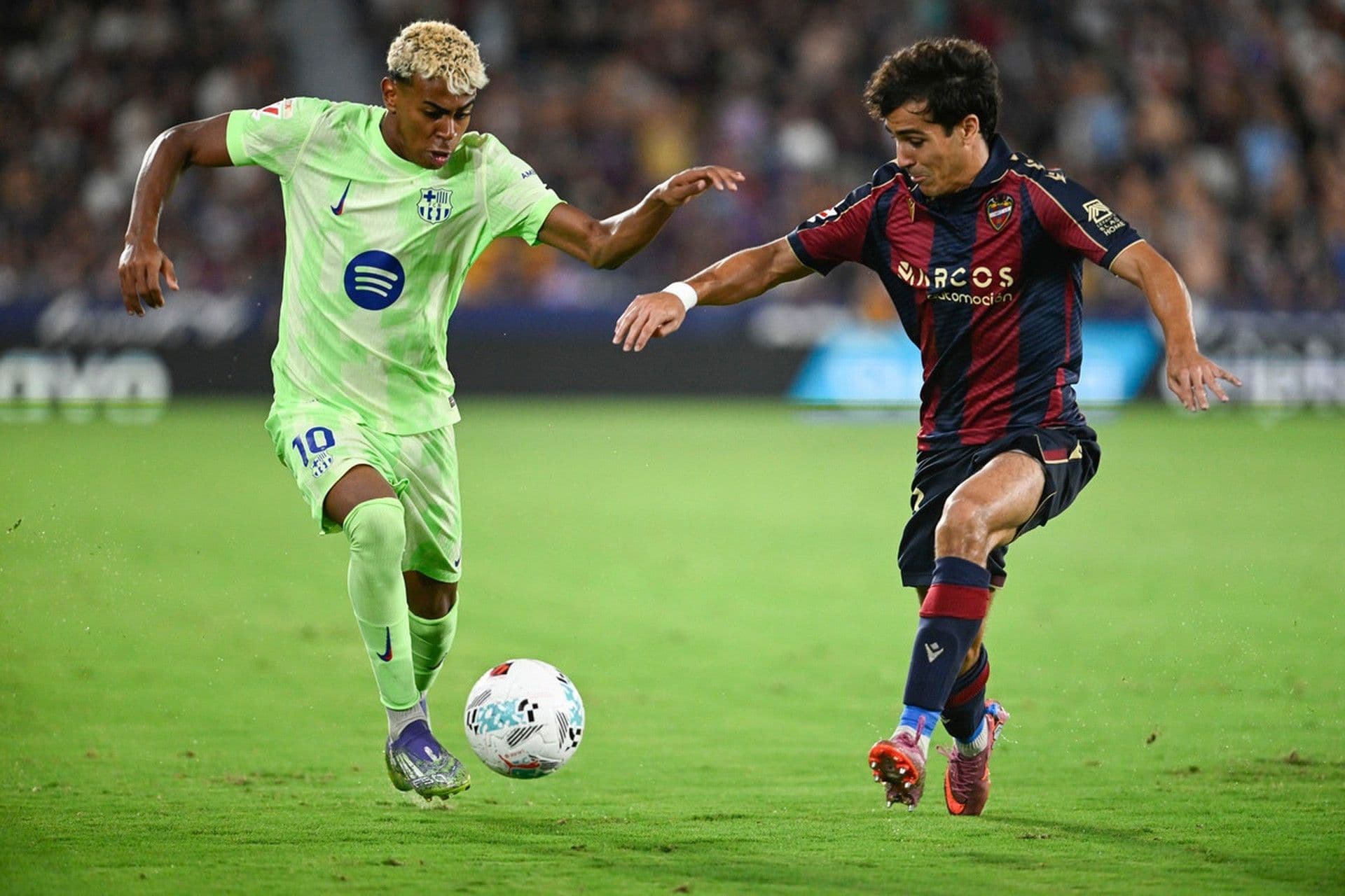 Cầu thủ Lamine Yamal của Barcelona đối đầu với cầu thủ Levante trong trận đấu.