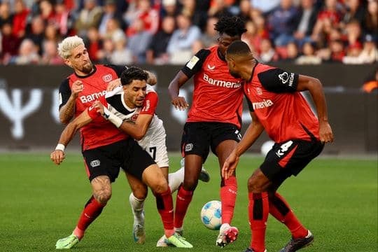 Cầu thủ Leverkusen và Frankfurt tranh chấp bóng, minh họa sức mạnh ngầm và chiến thuật trong bóng đá Bundesliga