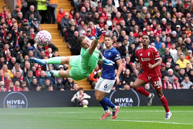 Cầu thủ Liverpool Ekitike dứt điểm hiểm hóc, thủ môn Pickford của Everton cố gắng cản phá.
