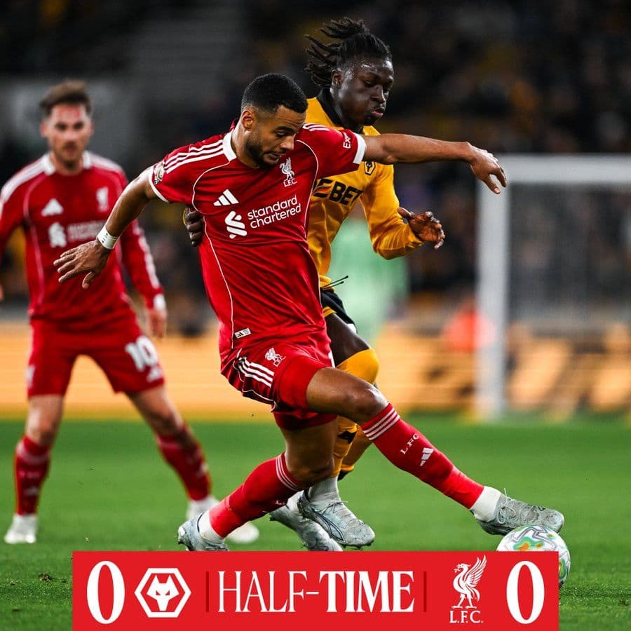 Cầu thủ Liverpool và Wolves tranh bóng, bảng tỷ số hiển thị 0-0 sau hiệp một.