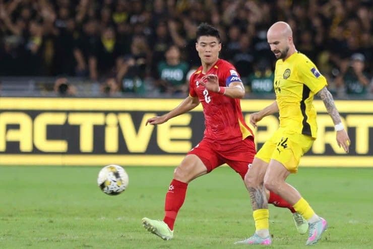 Cầu thủ Malaysia (áo vàng) và Việt Nam (áo đỏ) trong trận đấu bóng đá, minh họa cho bê bối nhập tịch cầu thủ của bóng đá Malaysia.