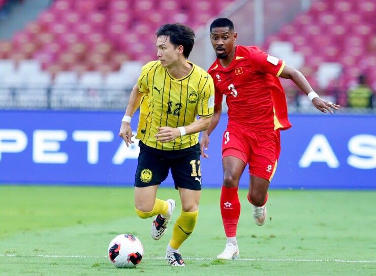 Cầu thủ Malaysia số 12 Manuel Hidalgo rê bóng dưới sự truy cản của cầu thủ Việt Nam số 3 trong trận đấu FIFA ASEAN Cup 2026.