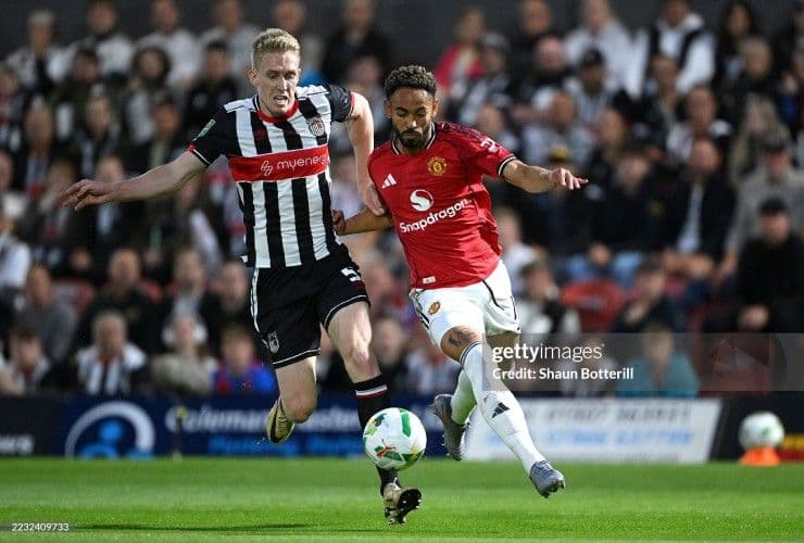 Cầu thủ Manchester United (áo đỏ) tranh bóng với đối thủ Grimsby Town trong trận thua sốc tại League Cup.