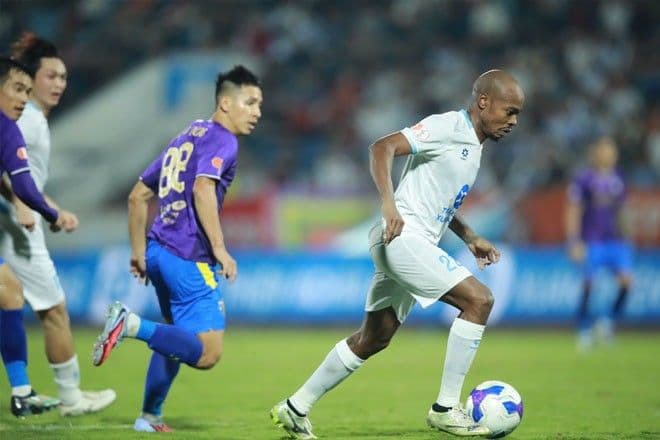 Cầu thủ Muzi Tau của Nam Định nỗ lực đi bóng qua đối thủ Hà Nội FC.