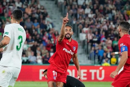 Cầu thủ ăn mừng bàn thắng, tượng trưng cho sự hiệu quả của một triết lý bóng đá trong cuộc đối đầu chiến thuật.