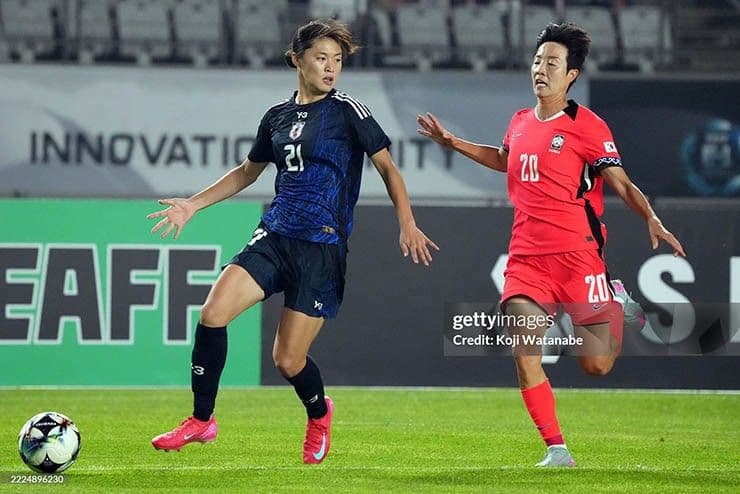 Cầu thủ nữ Nhật Bản (áo xanh sẫm) và Hàn Quốc (áo đỏ) trong trận đấu kịch tính