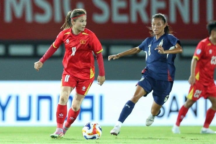 Cầu thủ nữ Việt Nam số 11 tranh bóng với cầu thủ Thái Lan.