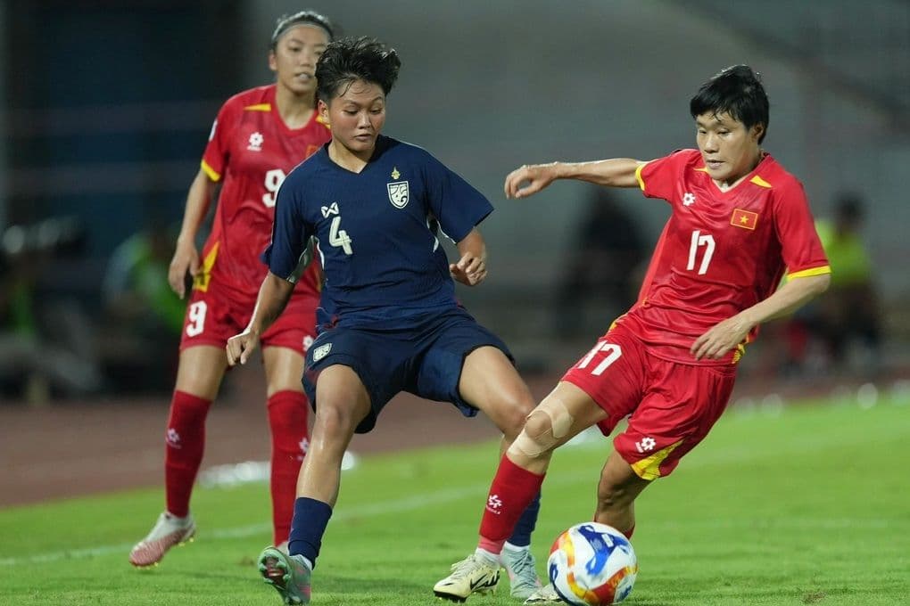 Cầu thủ nữ Việt Nam tranh bóng quyết liệt với đối thủ Thái Lan trong trận đấu quan trọng.