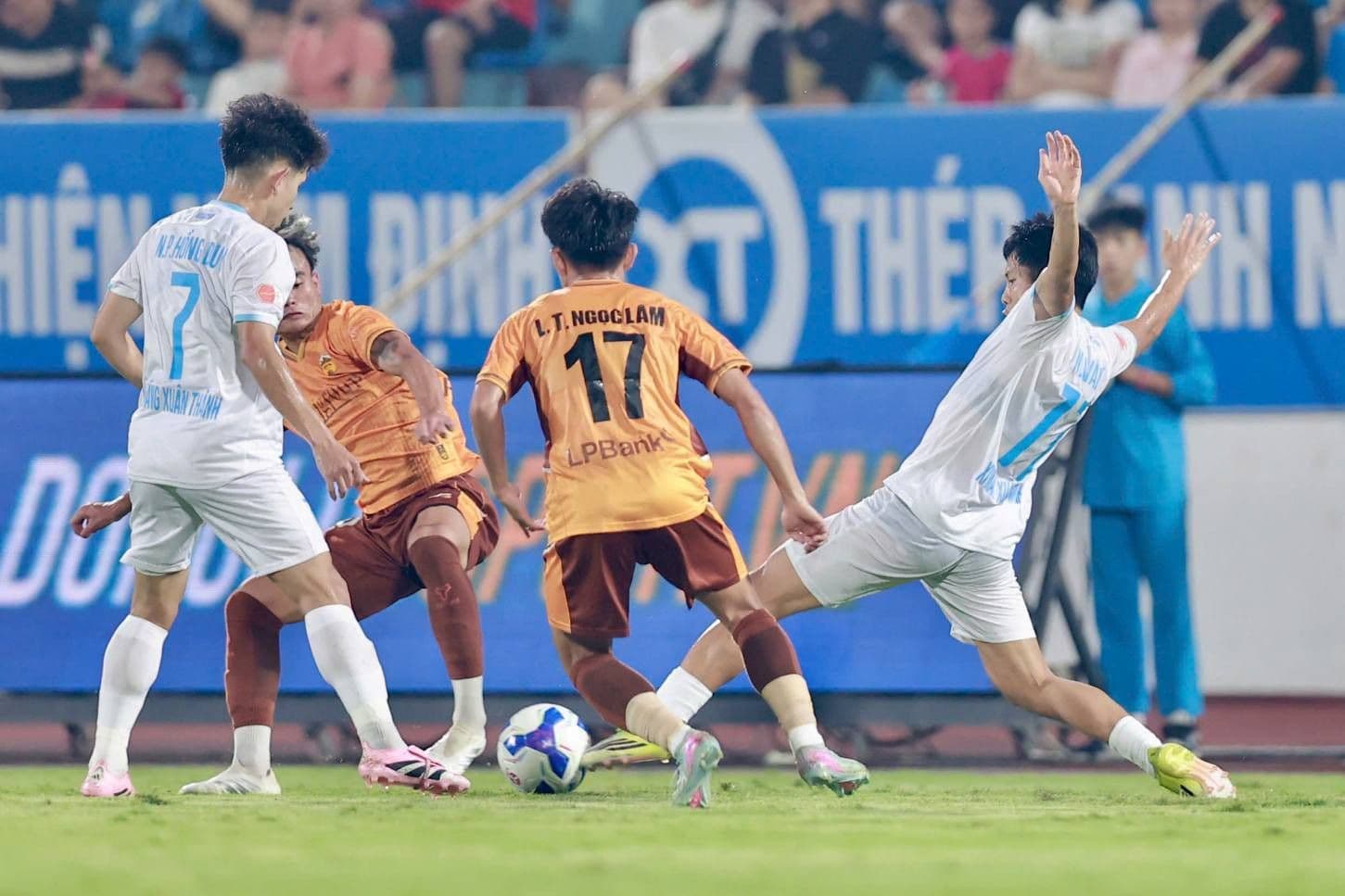 Cầu thủ Nam Định bị đối phương truy cản, thể hiện gánh nặng kỳ vọng