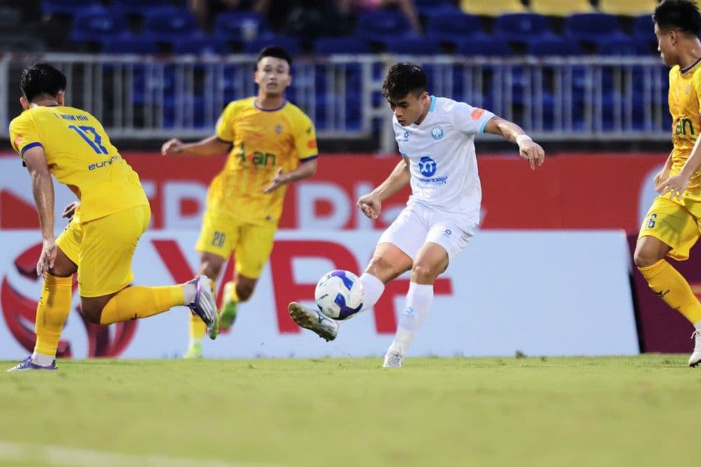 Cầu thủ Nam Định dứt điểm trong vòng vây của cầu thủ SLNA.