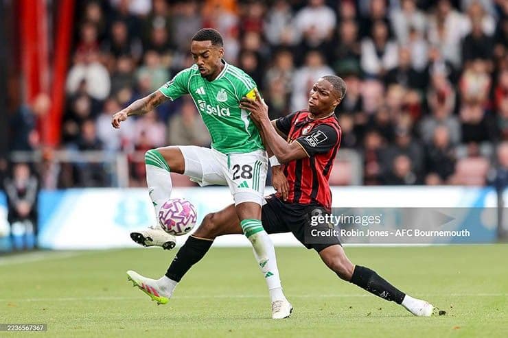 Cầu thủ Newcastle kiên cường tranh chấp bóng với đối thủ Bournemouth trong trận đấu đầy thử thách.