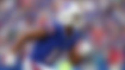 Cầu thủ NFL chạy với bóng, thể hiện sự kiên cường và nỗ lực vượt qua khó khăn, kể cả chấn thương.