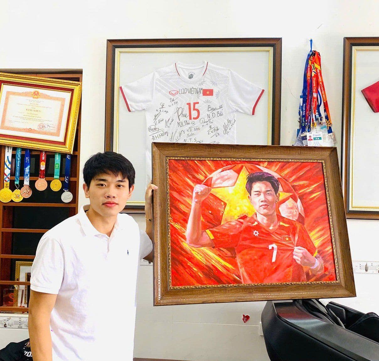 Cầu thủ Nguyễn Đình Bắc với bức tranh và áo đấu của mình, thể hiện bản sắc một tài năng sân cỏ được yêu mến.