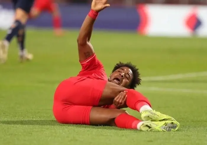 Cầu thủ nằm sân vì chấn thương, minh họa cho những yếu tố bất ngờ có thể xảy ra trong trận đấu