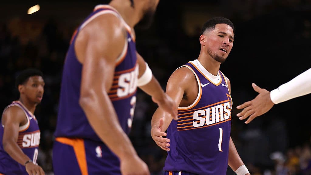 Cầu thủ Phoenix Suns Devin Booker và đồng đội trên sân, thể hiện tinh thần và tham vọng của đội trong tiền mùa giải NBA.