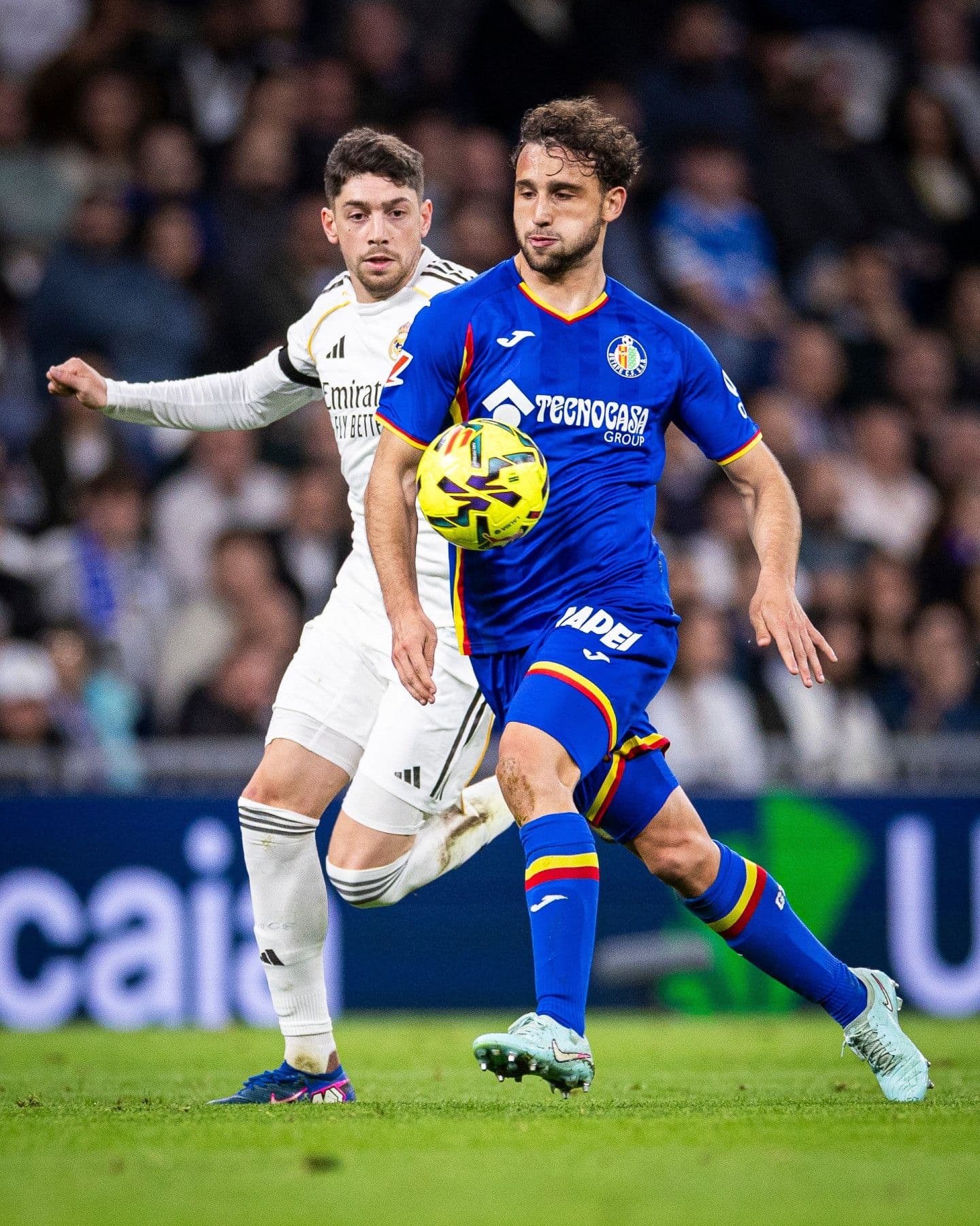 Cầu thủ Real Madrid đối đầu quyết liệt với cầu thủ Getafe, thể hiện áp lực không gian mà Getafe tạo ra.