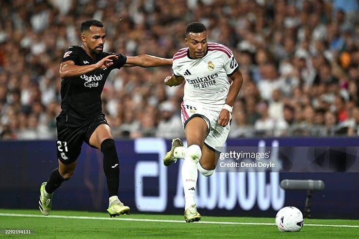Cầu thủ Real Madrid (áo trắng) tranh bóng với đối thủ Real Sociedad trong trận thắng 4-1.