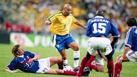Cầu thủ Ronaldo của Brazil đối đầu với các cầu thủ Pháp trong một trận đấu bóng đá đỉnh cao.