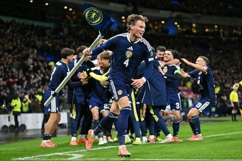 Cầu thủ Scotland Scott McTominay ăn mừng bàn thắng với cờ đội tuyển trên sân vận động Hampden Park.