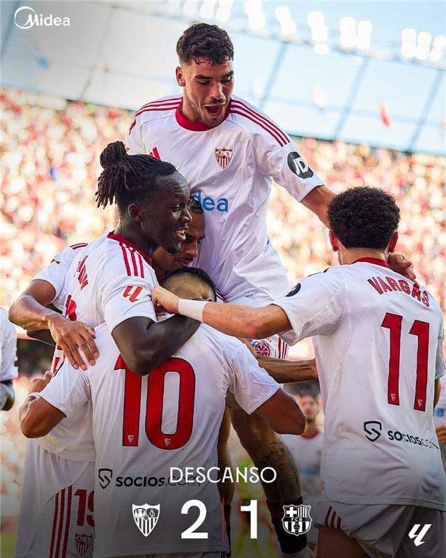 Cầu thủ Sevilla ăn mừng bàn thắng, bảng tỷ số hiển thị Sevilla dẫn trước Barcelona 2-1 ở hiệp một.