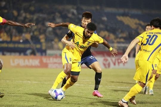 Cầu thủ SHB Đà Nẵng và Sông Lam Nghệ An tranh chấp bóng trong trận đấu quan trọng