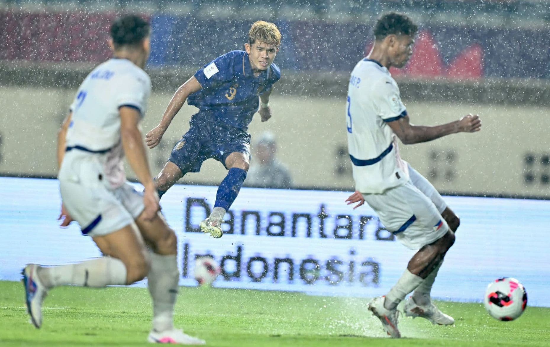 Cầu thủ Thái Lan và Philippines tranh bóng dưới mưa trong trận đấu FIFA ASEAN Cup 2026