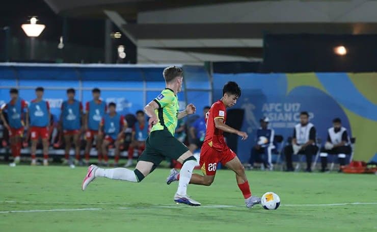 Cầu thủ U17 Việt Nam (áo đỏ) tranh bóng với cầu thủ U17 Australia trong trận tứ kết U17 châu Á
