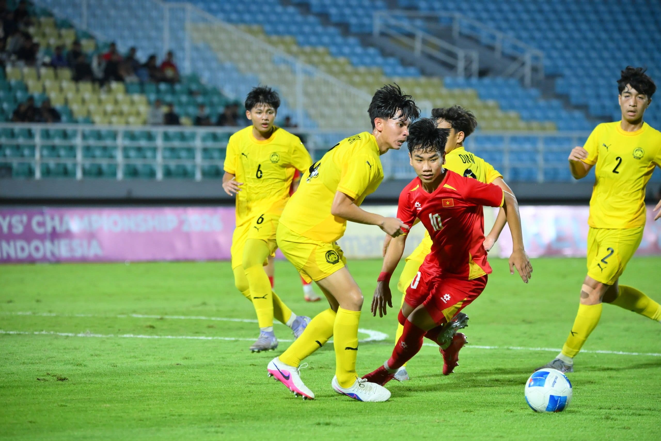 Cầu thủ U17 Việt Nam (áo đỏ) vượt qua các cầu thủ U17 Malaysia (áo vàng) trong trận đấu chung kết U17 Đông Nam Á 2026.