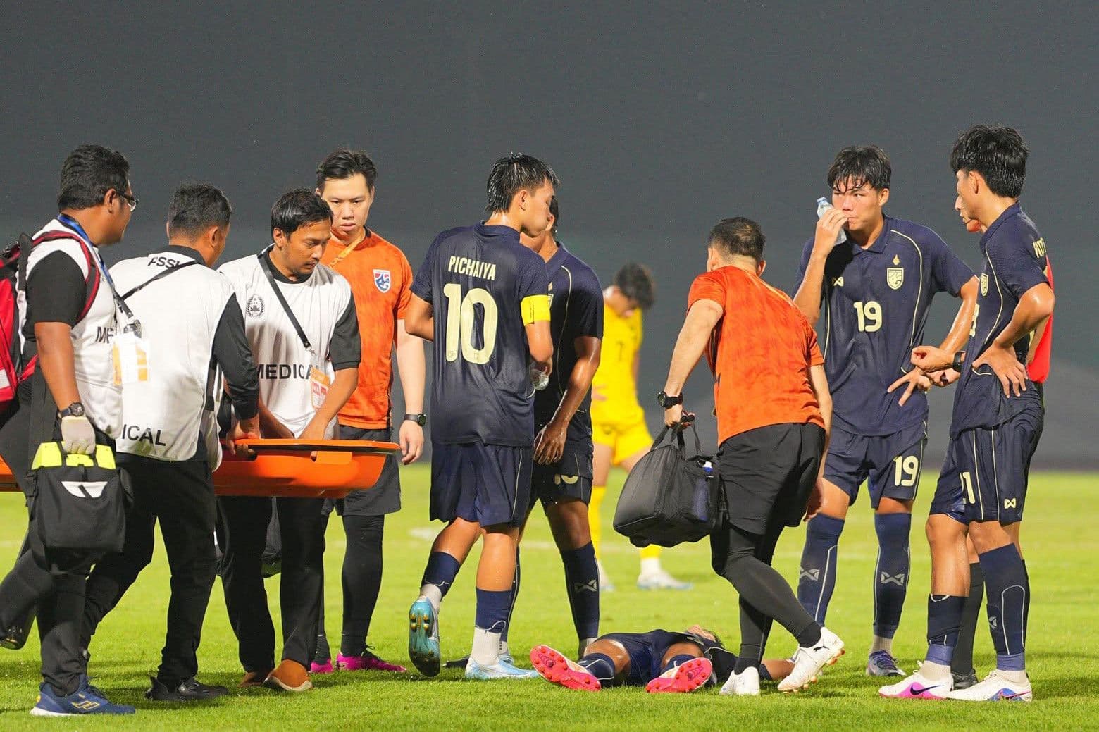 Cầu thủ U19 Thái Lan nhận sự chăm sóc y tế trên sân, minh họa những bài học xương máu trong bóng đá