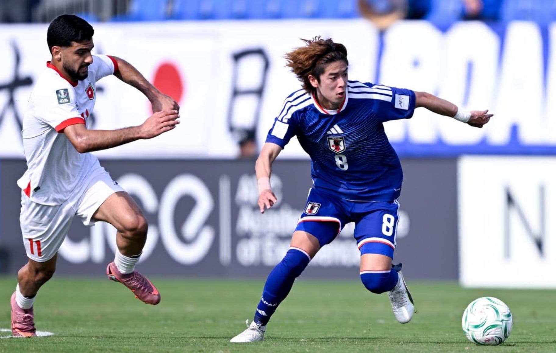 Cầu thủ U23 Nhật Bản đang tấn công với bóng trong trận đấu.