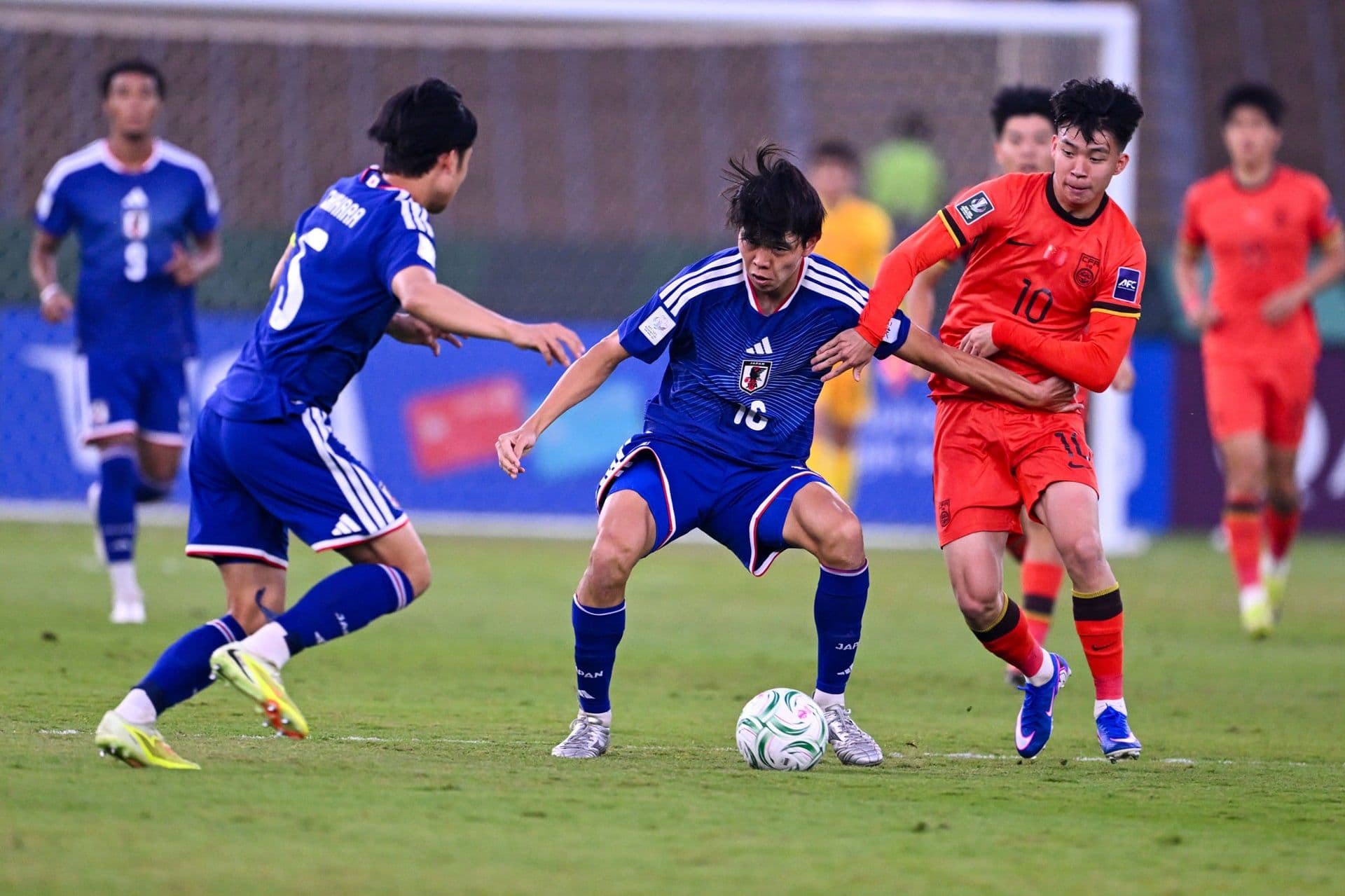 Cầu thủ U23 Nhật Bản kiểm soát bóng trước sự truy cản của U23 Trung Quốc, thể hiện sự áp đảo về kỹ thuật.