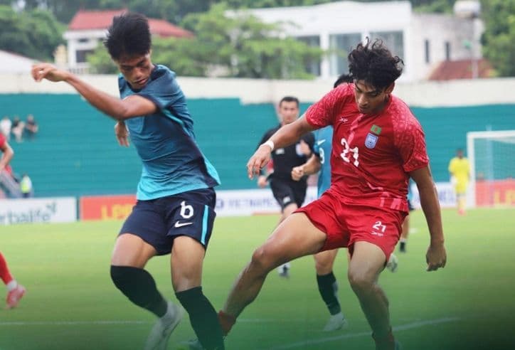 Cầu thủ U23 Singapore nỗ lực kiểm soát bóng dưới áp lực từ đối thủ, tượng trưng cho thách thức của U23 Trung Quốc.