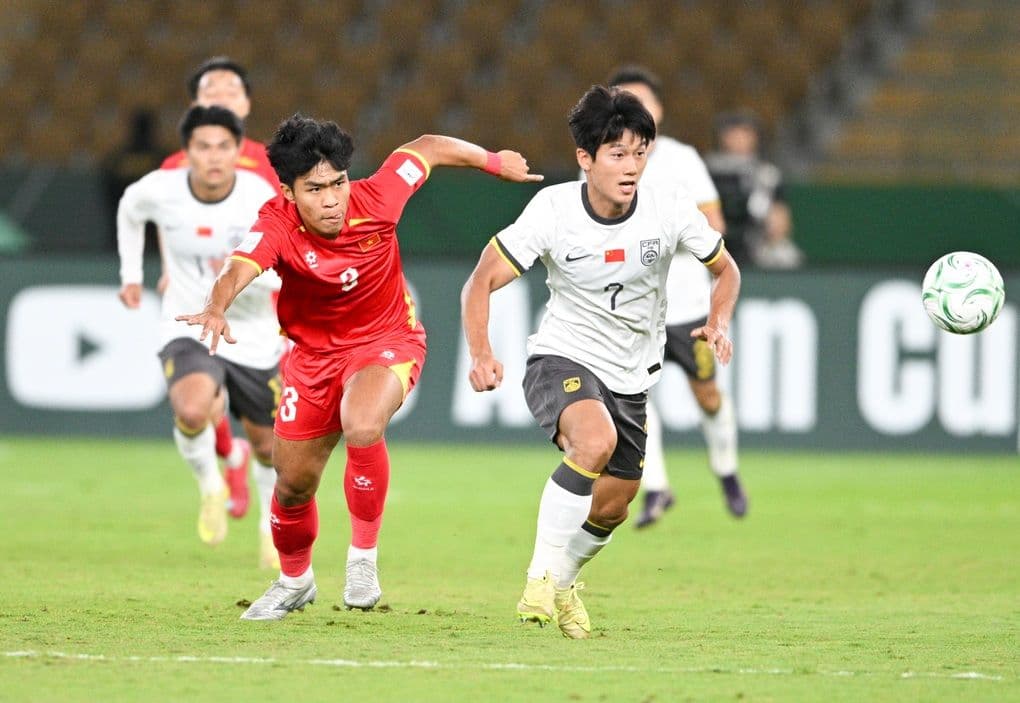 Cầu thủ U23 Trung Quốc (áo trắng) tranh bóng với cầu thủ U23 Việt Nam (áo đỏ) tại giải U23 châu Á