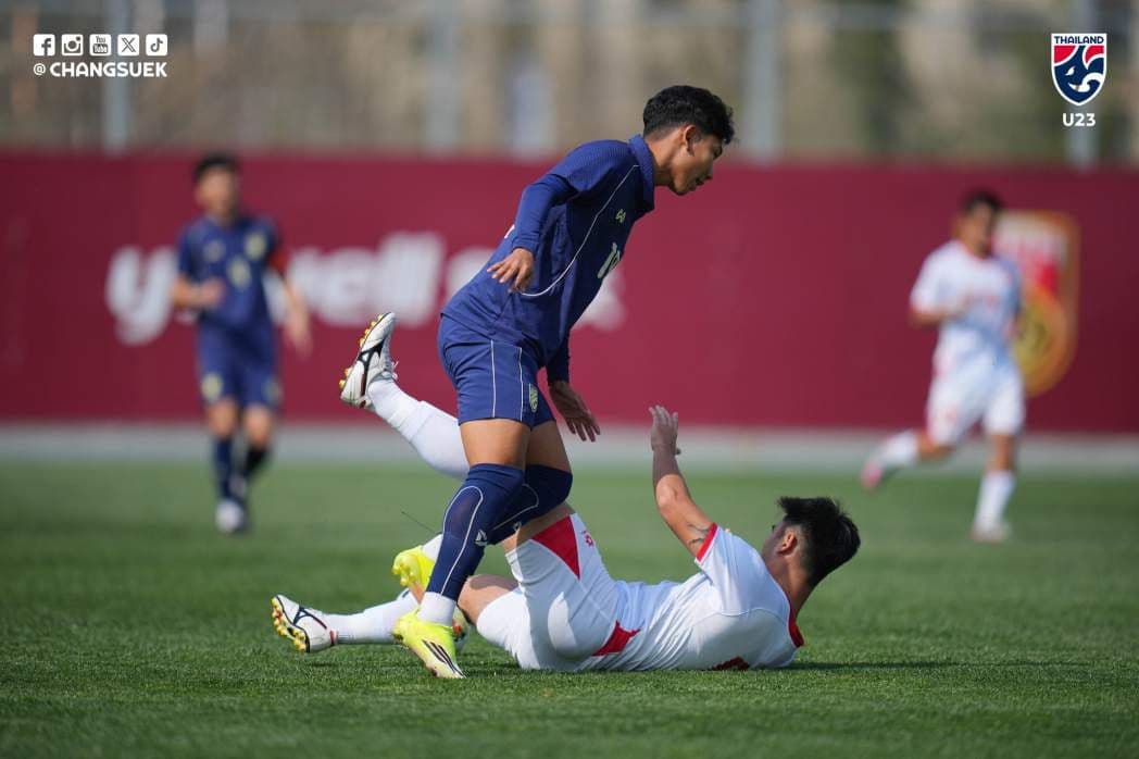 Cầu thủ U23 Việt Nam nằm sân sau pha tranh chấp với đối thủ U23 Thái Lan, thể hiện sự khó khăn trong trận đấu.