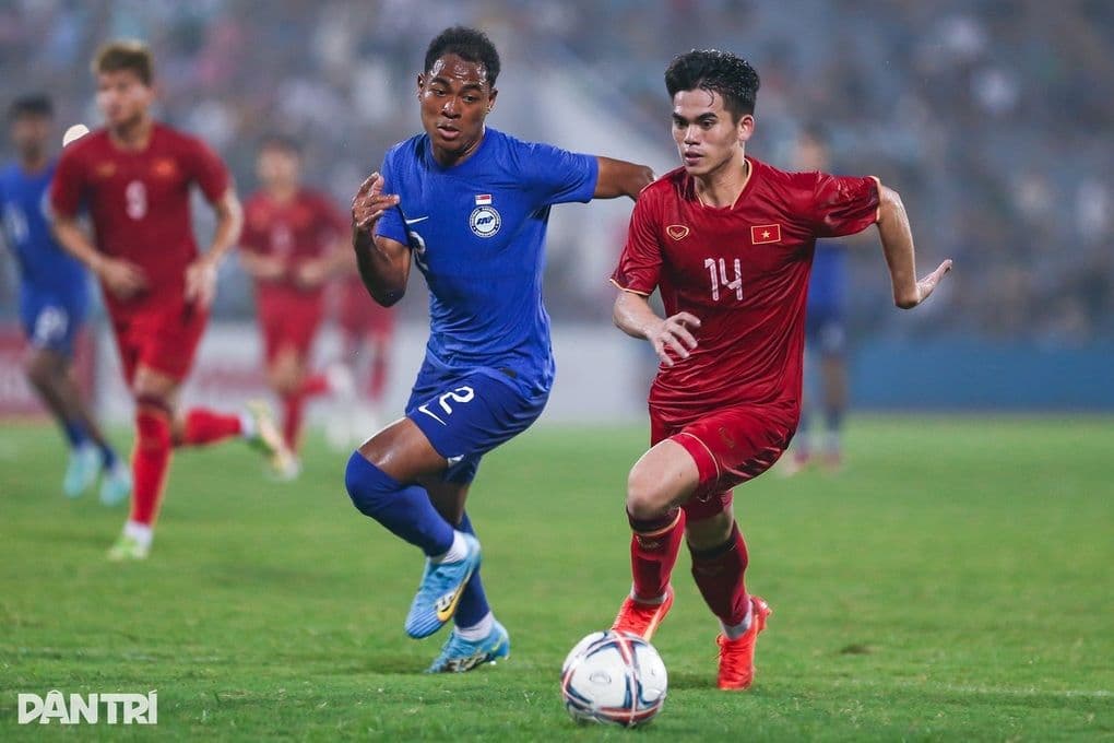 Cầu thủ U23 Việt Nam số 14 tranh bóng với cầu thủ U23 Singapore trong trận đấu vòng loại U23 châu Á.