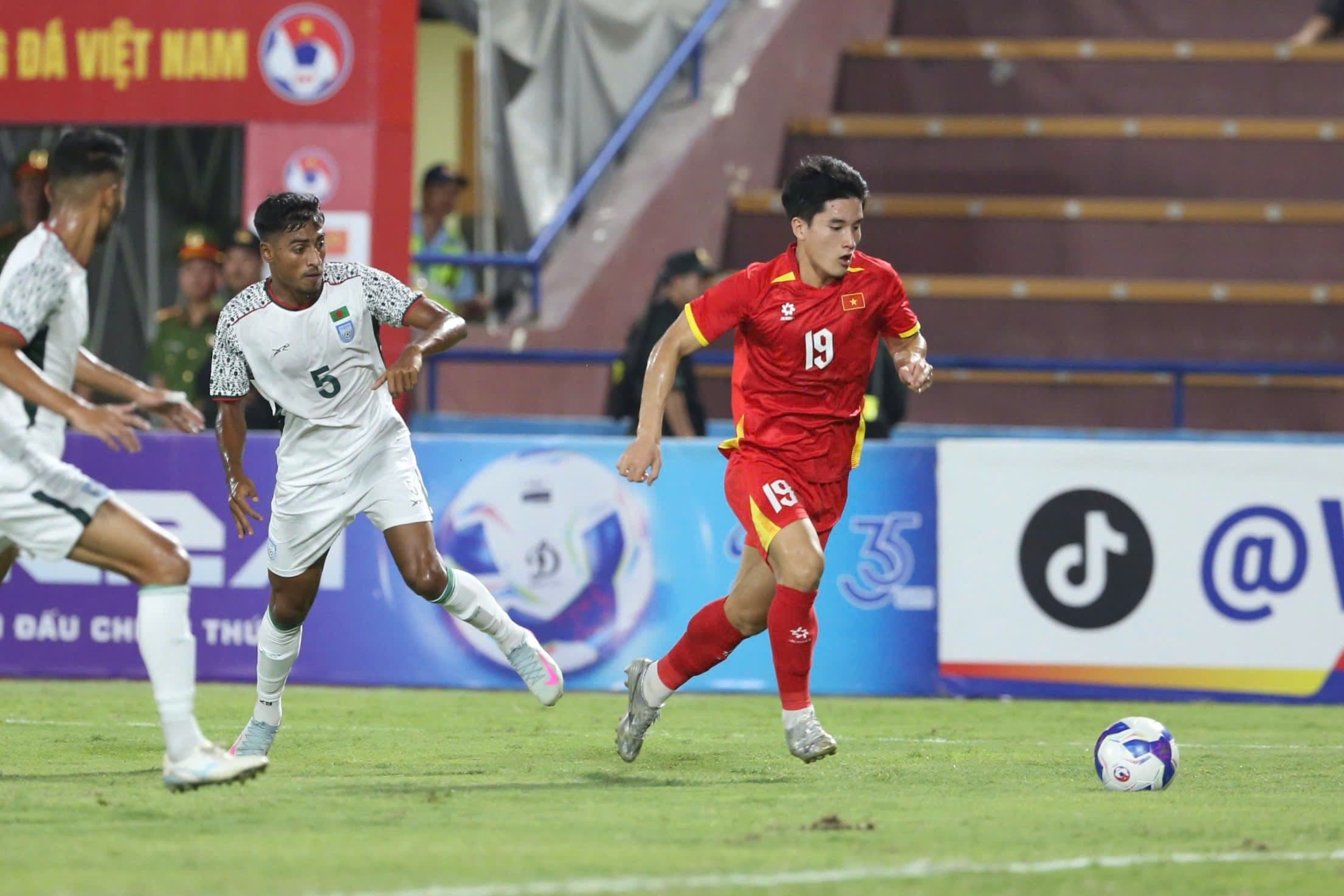 Cầu thủ U23 Việt Nam số 19 tranh bóng với đối thủ U23 Bangladesh.