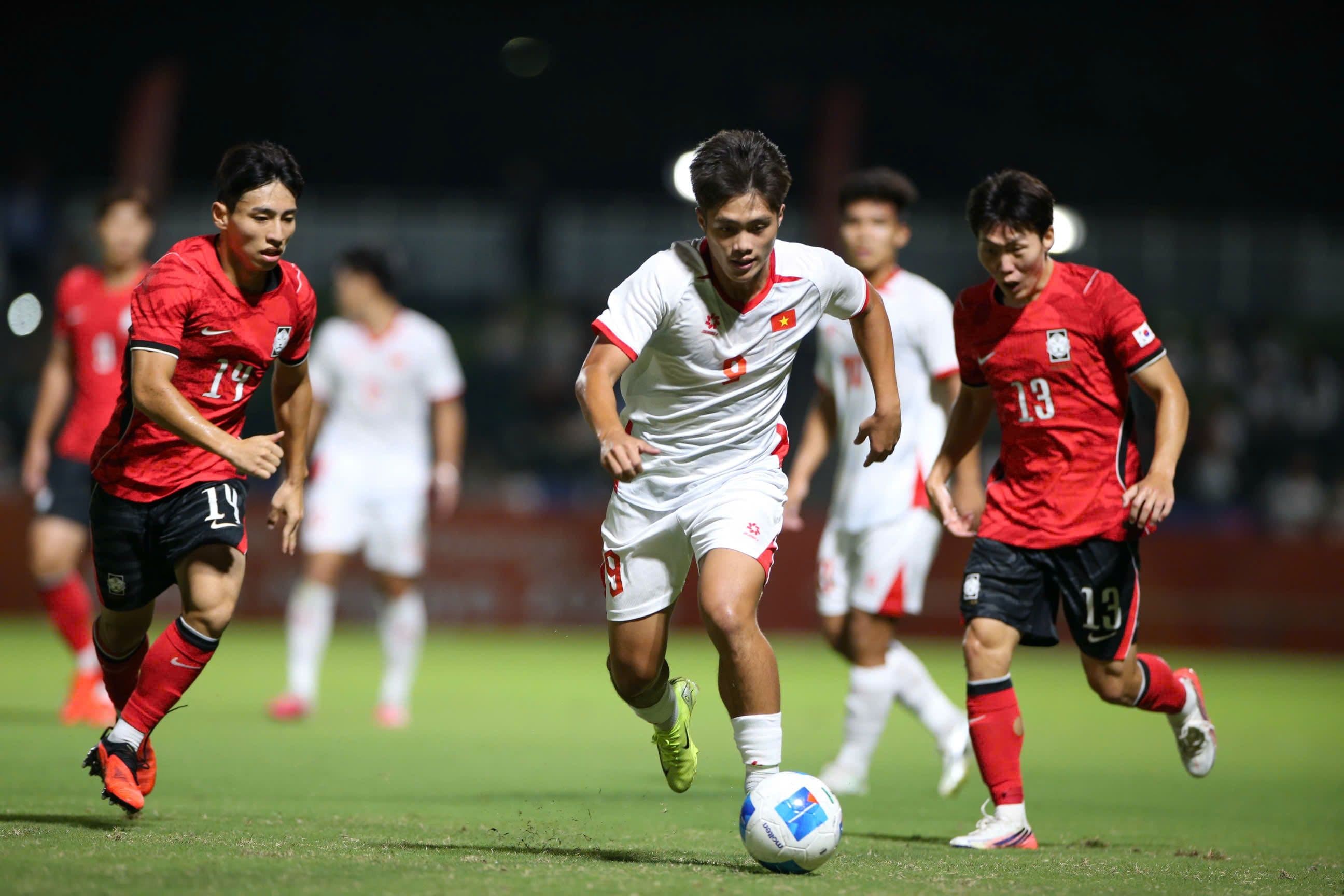 Cầu thủ U23 Việt Nam số 9 nỗ lực đi bóng vượt qua hai cầu thủ U23 Hàn Quốc.