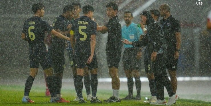 Cầu thủ và ban huấn luyện U23 Thái Lan thảo luận dưới mưa lớn trong trận gặp Lebanon.