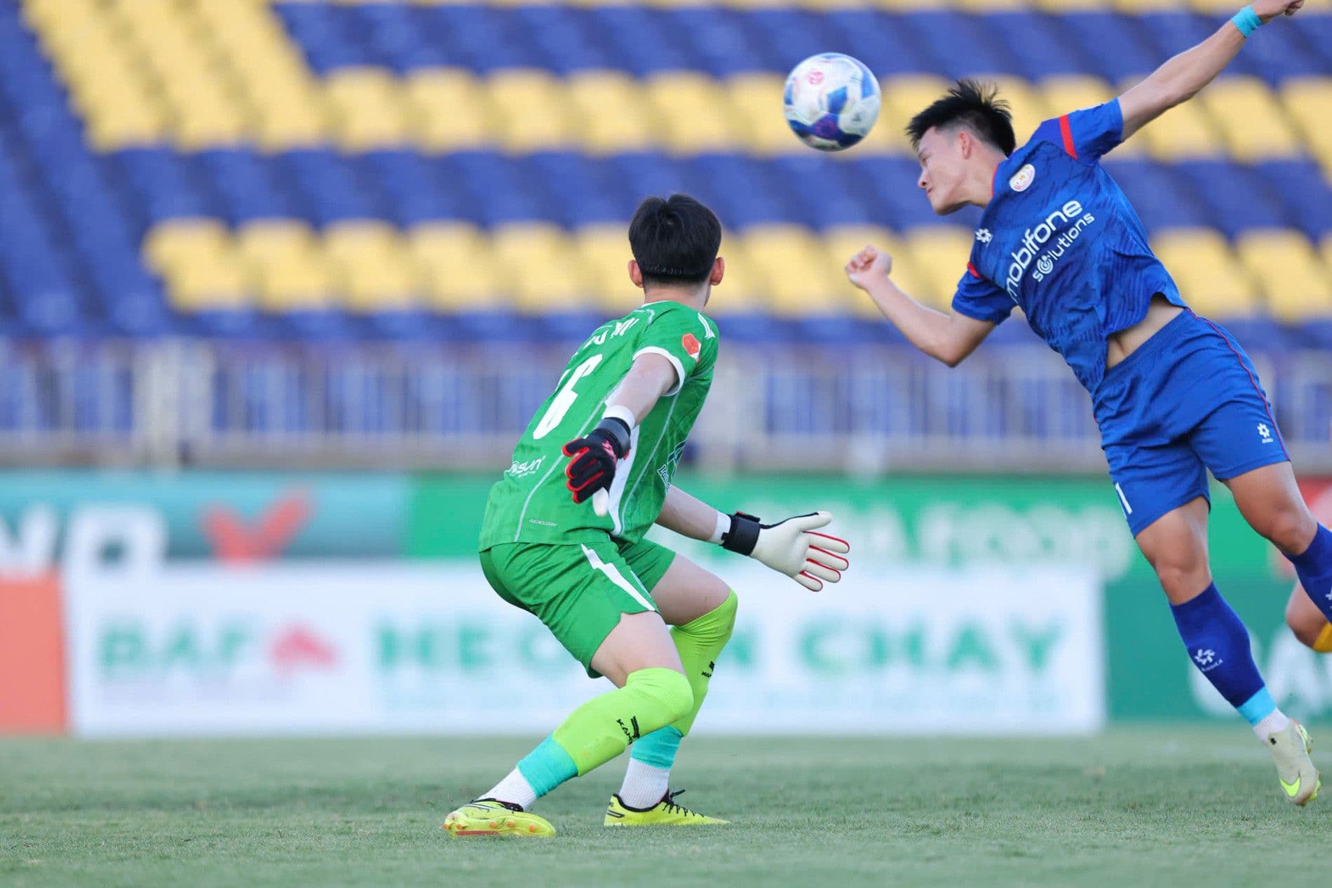 Cầu thủ V-League tranh chấp bóng trên sân, gợi lên hình ảnh các trận đấu diễn ra trong điều kiện hạ tầng sân vận động hiện tại