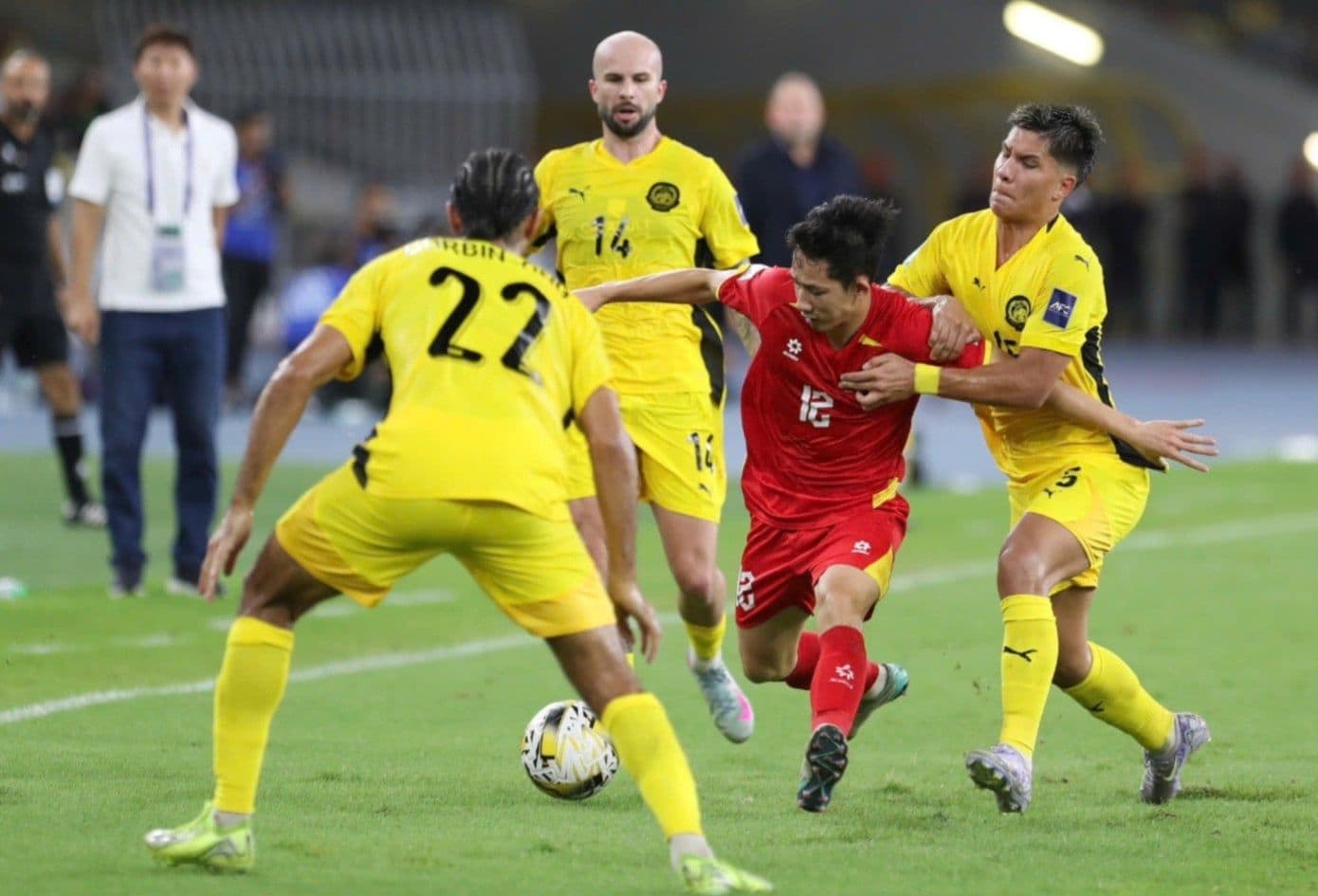 Cầu thủ Việt Nam (áo đỏ) đối đầu cầu thủ Malaysia (áo vàng) trong trận đấu bóng đá, minh họa cho án phạt và vấn đề nhập tịch